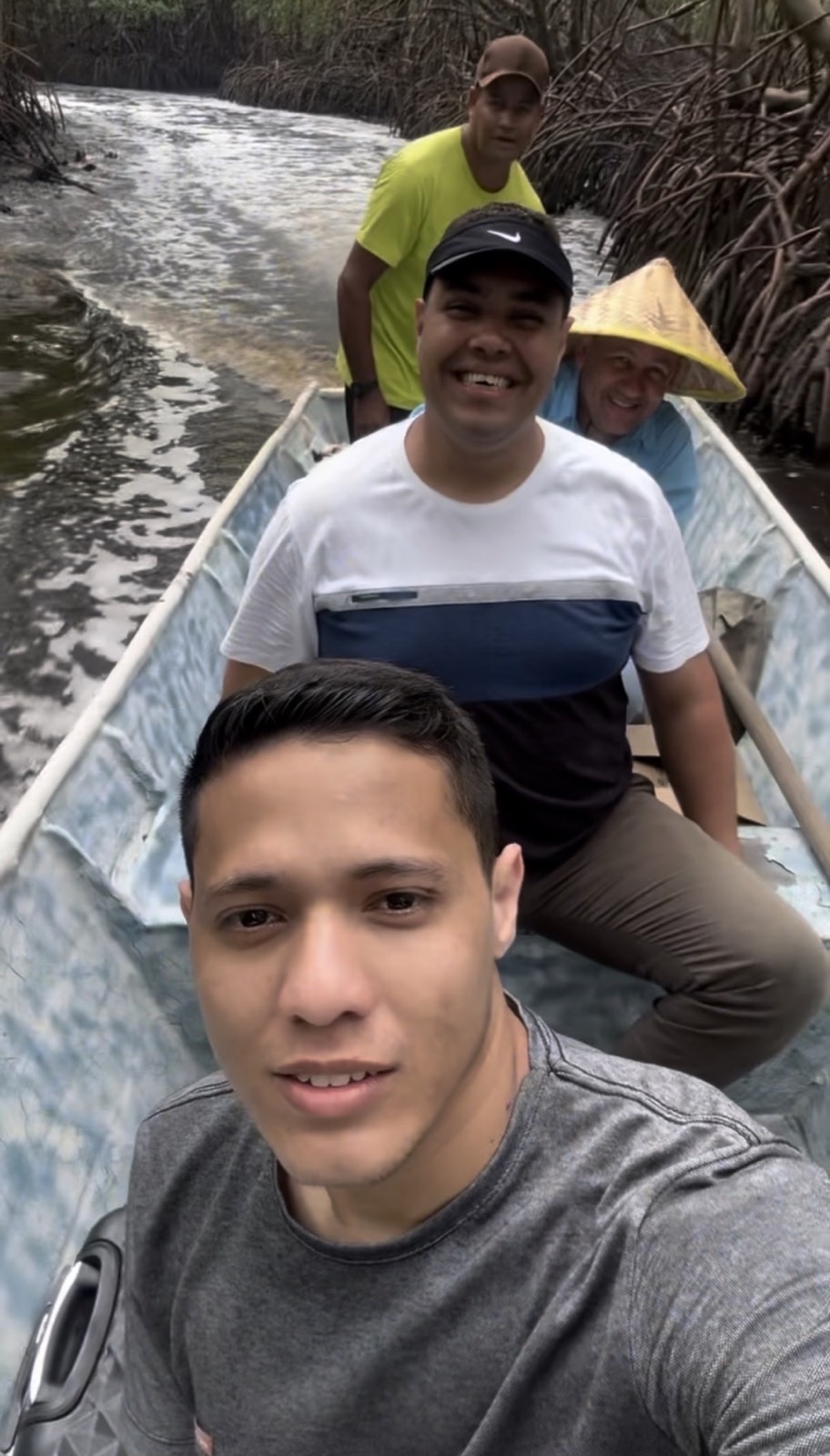Equipe missionária viajando de barco por uma região de mangue no Brasil