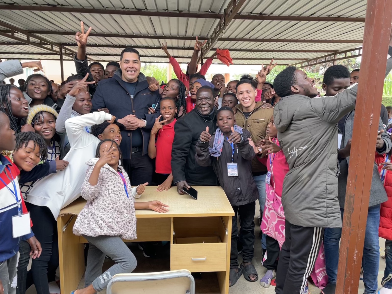 Missionários reunidos com um grande grupo de crianças e jovens em Angola