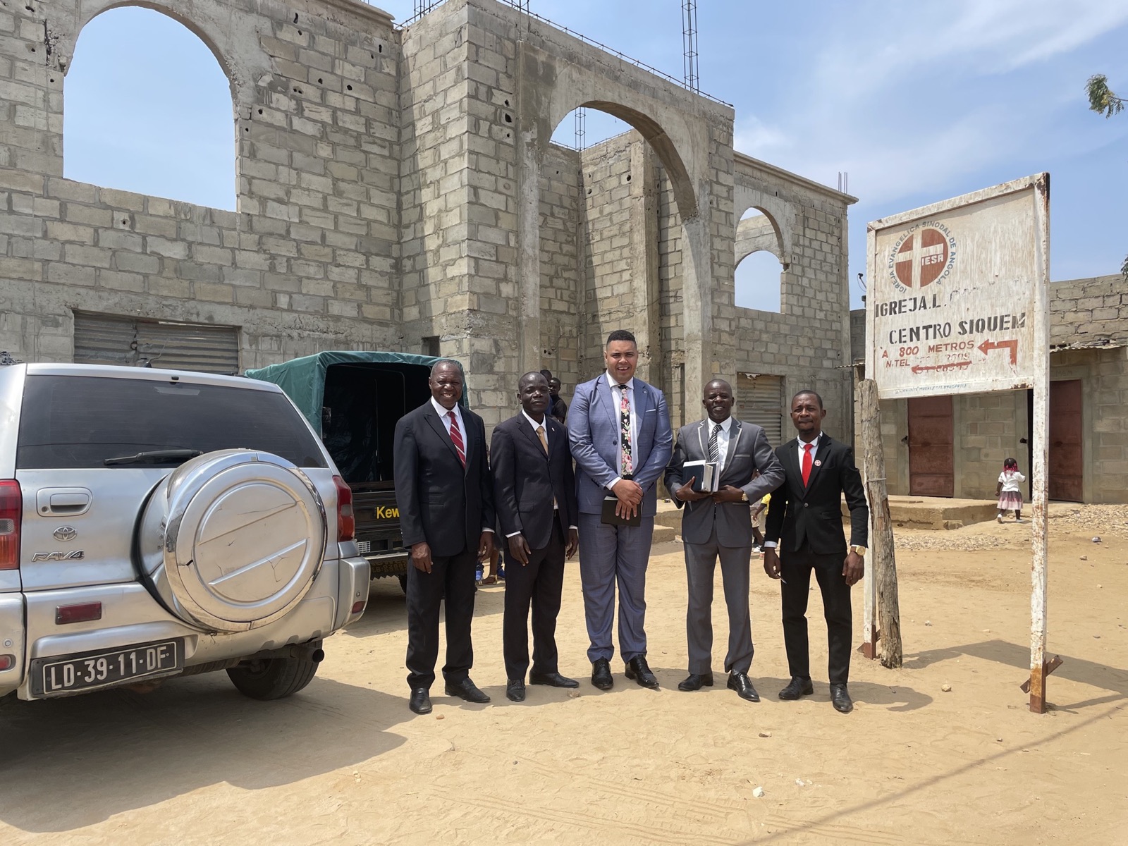 Lideranças missionárias diante de uma igreja em construção em Angola